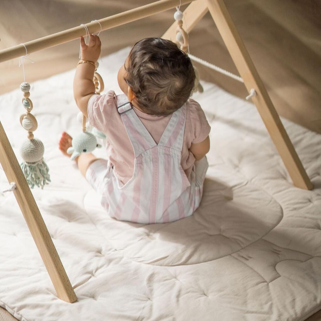 Krabbeldecke Yume von Minik Moon, Baby auf Decke mit Spielbogen